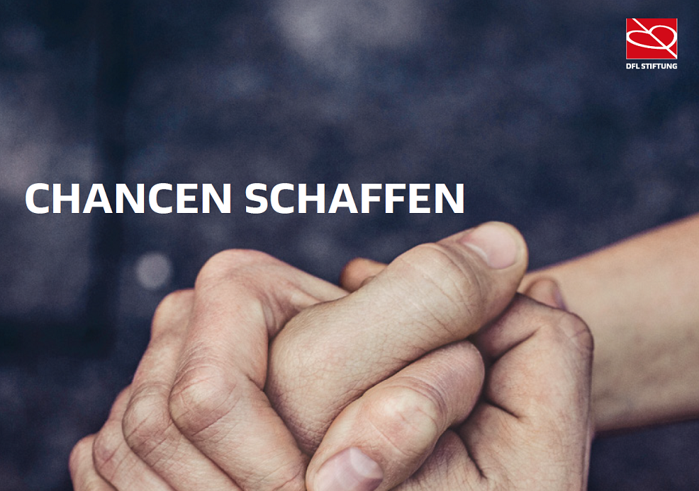 Zwei Hände reichen sich auf dunkelgrauem Hintergrund - 