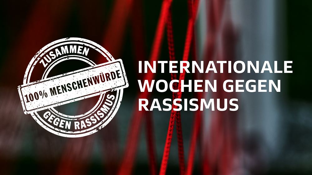 "Logo '100% Menschenwürde – Gegen Rassismus' vor rotem, verschwommenem Hintergrund mit dem Text 'Internationale Wochen gegen Rassismus'."