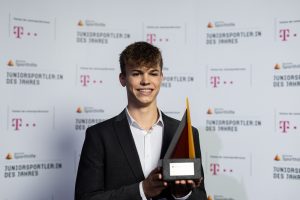 Taliso Engel, Para-Juniorsportler des Jahres 2021, hält lächelnd eine Auszeichnung in der Hand.