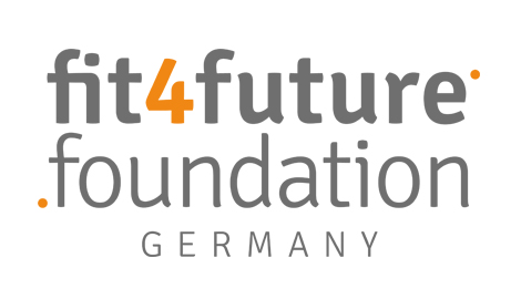Runder Tisch mit mehreren Männern in legerer bis formeller Kleidung, die in Sesseln sitzen und diskutieren. Im Hintergrund ist ein Banner mit dem Logo der DFL Stiftung zu sehen.