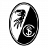 Logo SC Freiburg Freudiger Fredi Bobic nimmt an einem Lauf gegen Rassismus teil, gekleidet in einem weißen T-Shirt mit dem Aufdruck "Lauf gegen Rassismus" und dem Logo der DFL Stiftung. Im Hintergrund sind weitere Läufer zu sehen.