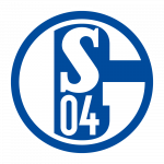 Freiwillige Frauen stehen hinter einem Imbissstand mit verschiedenen Speisen und Gebäck, wahrscheinlich auf einem Fußballstadion. Sie lächeln in die Kamera.