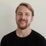 Club-Vertreter sitzen an einer Bar und diskutieren angeregt, im Hintergrund weitere Teilnehmer einer Veranstaltung, die von der DFL Stiftung organisiert wurde.