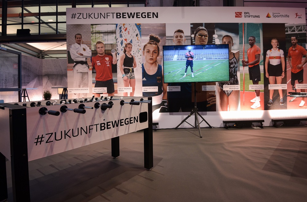 Elisabeth Seitz, Porträt zur Hälfte im Schatten, zur Hälfte im Licht, mit dem Schriftzug "SEITE AN SEITE" im dunklen Bereich. Logos der DFL Stiftung und Deutsche Sporthilfe im unteren Bereich.