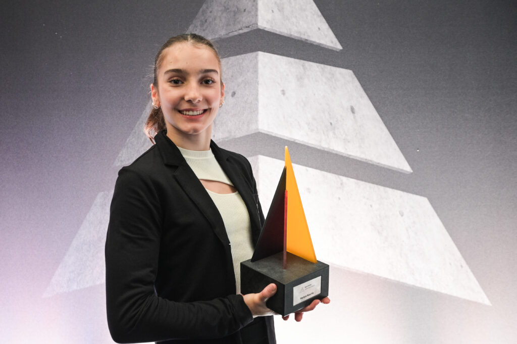 Helen Kevric, Juniorsportlerin des Jahres 2023 im Turnen, hält eine Trophäe in den Händen und lächelt in die Kamera.