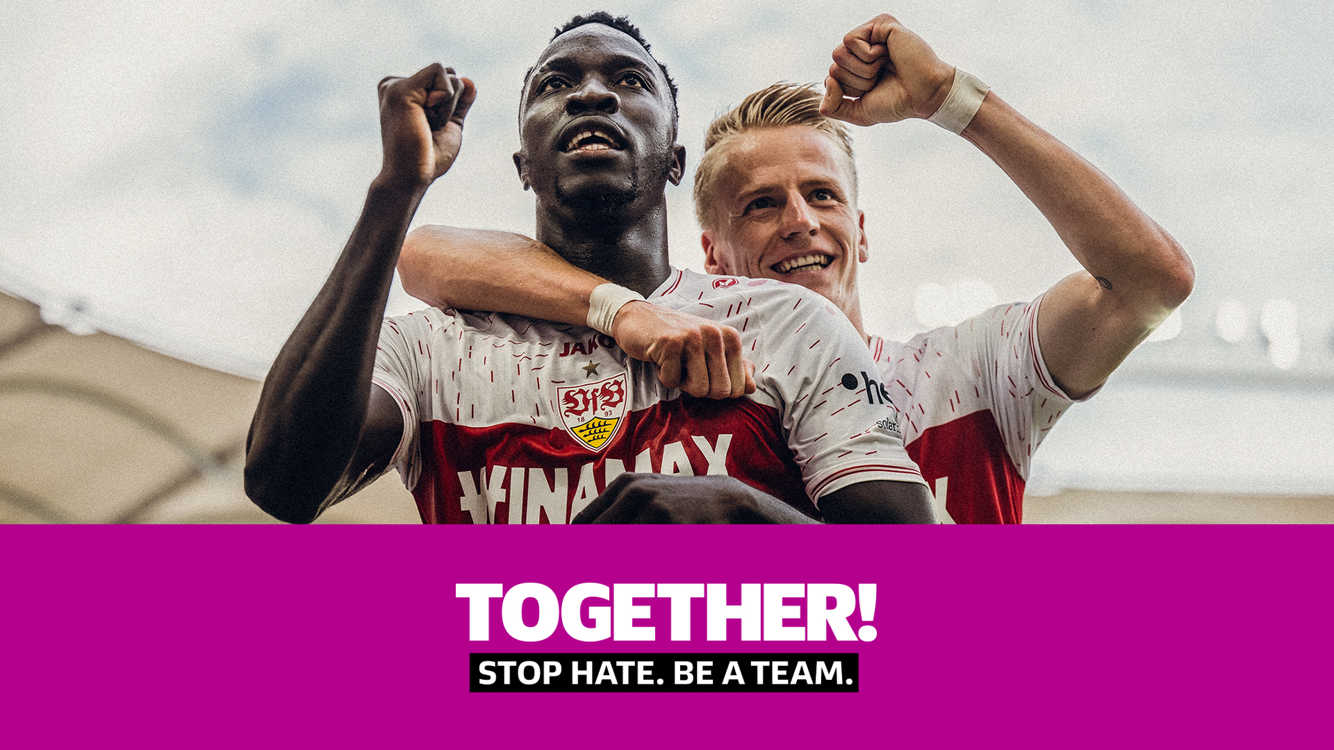 Zwei Fußballspieler, einer mit dunkler Hautfarbe und einer mit heller Hautfarbe, jubeln gemeinsam mit hoch erhobenen Armen. Sie tragen rote Trikots mit dem Schriftzug "SVS". Darunter steht in großen Buchstaben "TOGETHER!" und darunter kleiner "STOP HATE. BE A TEAM.".